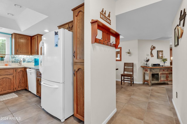 kitchen featuring white appliances, backsplash, and light tile patterned floors