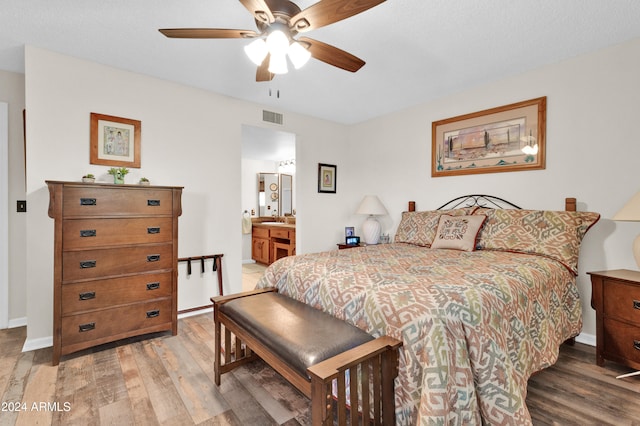 bedroom featuring ceiling fan, sink, ensuite bathroom, and hardwood / wood-style flooring