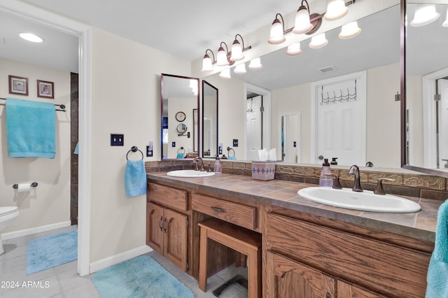 bathroom with tile patterned flooring, vanity, and toilet