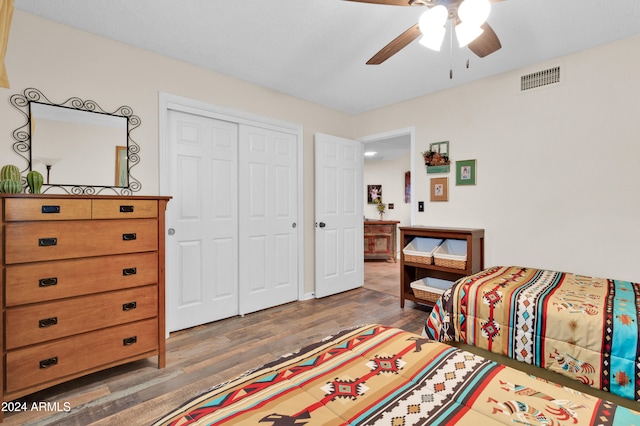 bedroom with a closet, ceiling fan, and dark wood-type flooring