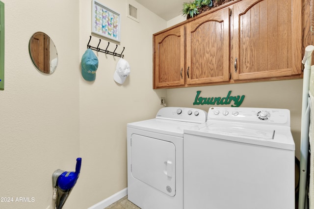 laundry room featuring separate washer and dryer and cabinets