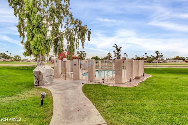 view of home's community with a lawn and a pool