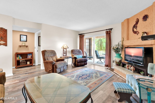 living room with light hardwood / wood-style floors and a textured ceiling