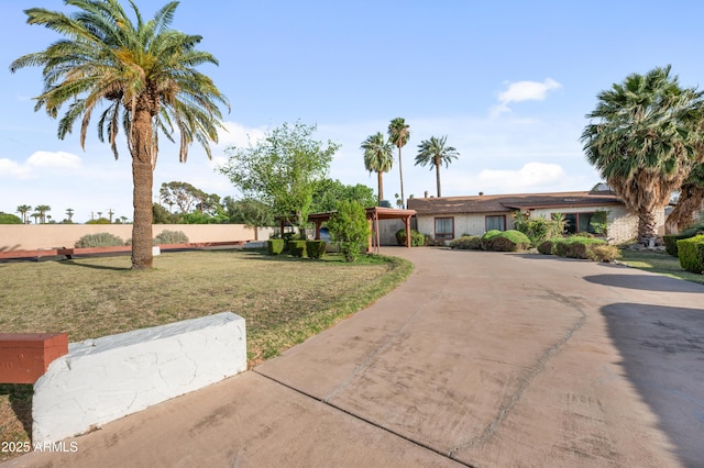 4461 E Flower St, Phoenix, AZ 85018 - ranch-style home featuring curved driveway, a front lawn, and a carport