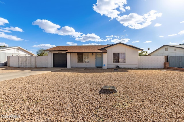 ranch-style home with a garage, fence, and driveway