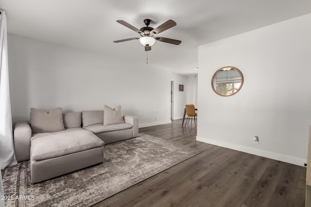 living area featuring a ceiling fan, baseboards, and wood finished floors