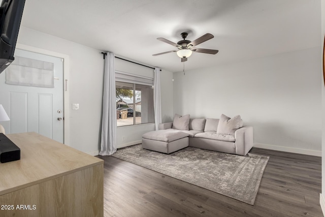 living room featuring ceiling fan, wood finished floors, and baseboards