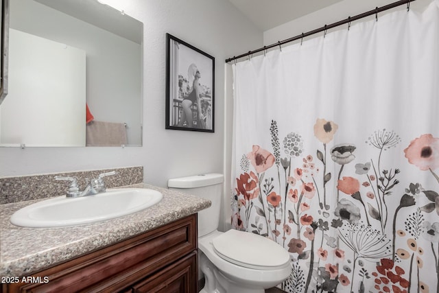 bathroom featuring curtained shower, vanity, and toilet