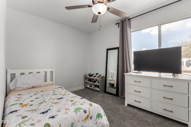 bedroom featuring baseboards, dark colored carpet, and a ceiling fan