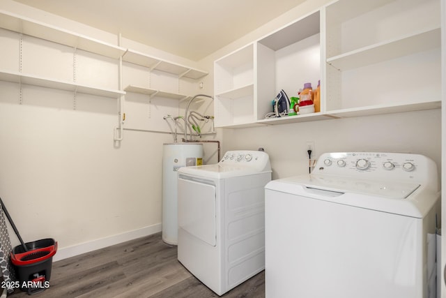 laundry room featuring laundry area, baseboards, wood finished floors, electric water heater, and washing machine and dryer