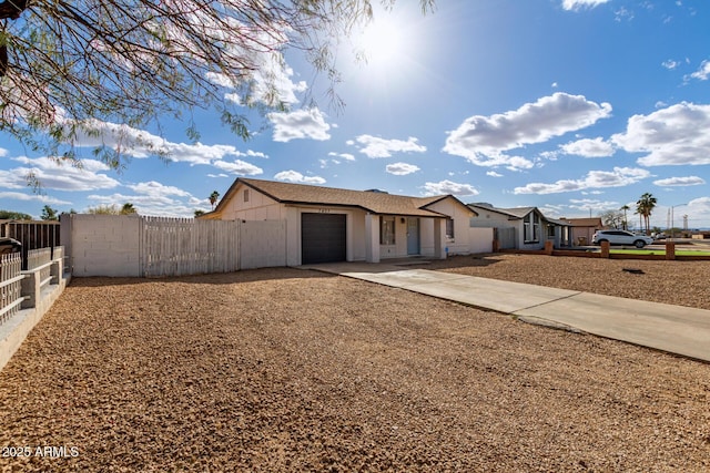 ranch-style home with driveway, an attached garage, and fence