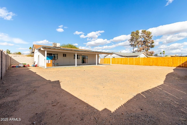 rear view of house with a fenced backyard, a patio, and central AC