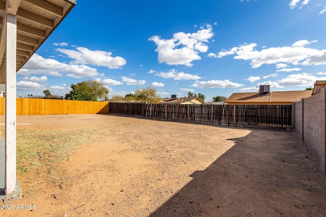 view of yard with fence and central AC