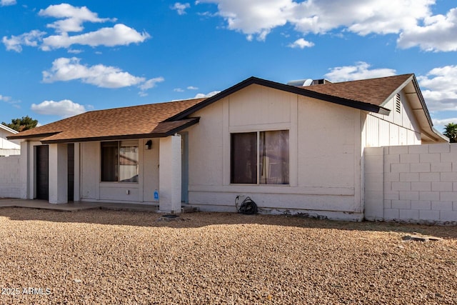 view of front of home featuring roof with shingles and fence