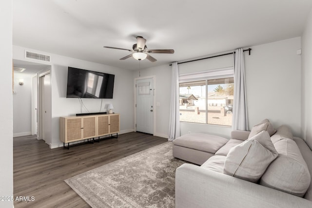 living area featuring visible vents, ceiling fan, baseboards, and wood finished floors