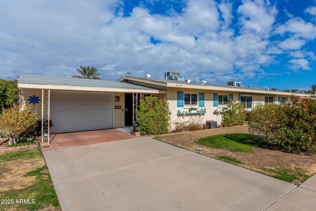 single story home featuring a garage and central air condition unit