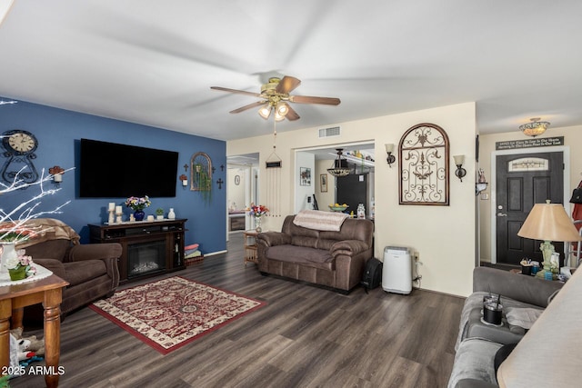 living room featuring ceiling fan and dark hardwood / wood-style floors