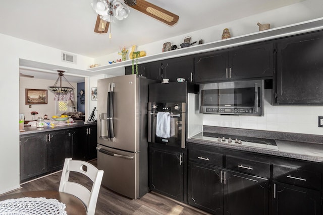 kitchen featuring stainless steel appliances, tasteful backsplash, hanging light fixtures, and dark hardwood / wood-style floors