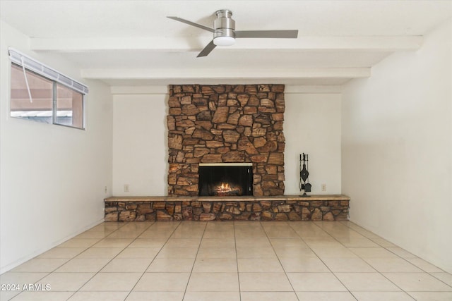 unfurnished living room with light tile patterned floors, a stone fireplace, ceiling fan, and beam ceiling