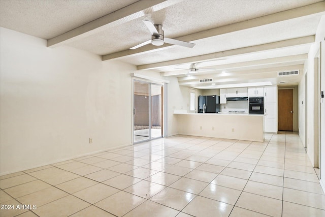 unfurnished living room featuring ceiling fan, light tile patterned floors, beamed ceiling, and a textured ceiling