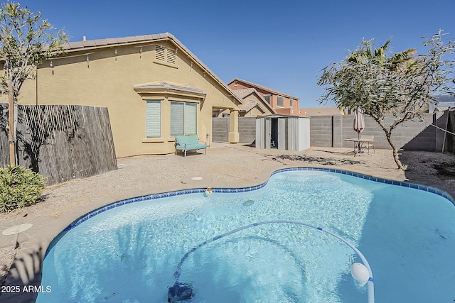 view of pool with an outdoor structure, a patio area, a fenced backyard, and a fenced in pool