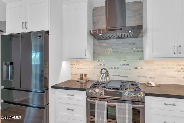 kitchen with wall chimney exhaust hood, appliances with stainless steel finishes, decorative backsplash, and white cabinets