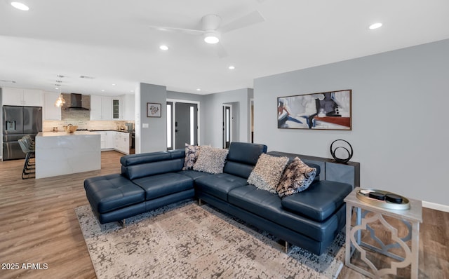 living room with ceiling fan and light wood-type flooring