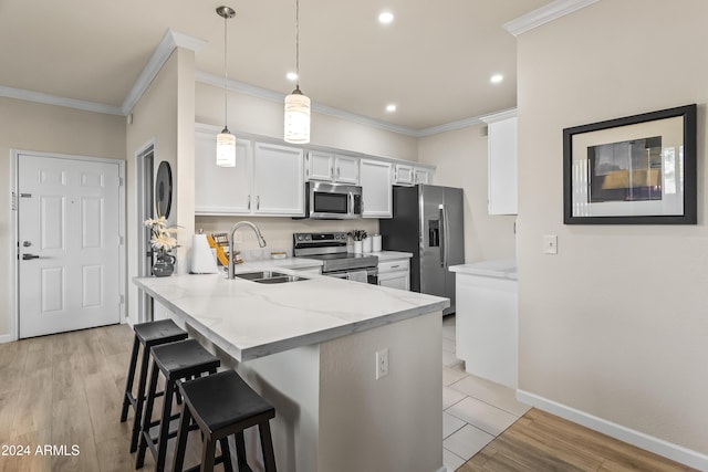 kitchen featuring white cabinets, sink, light wood-type flooring, kitchen peninsula, and stainless steel appliances