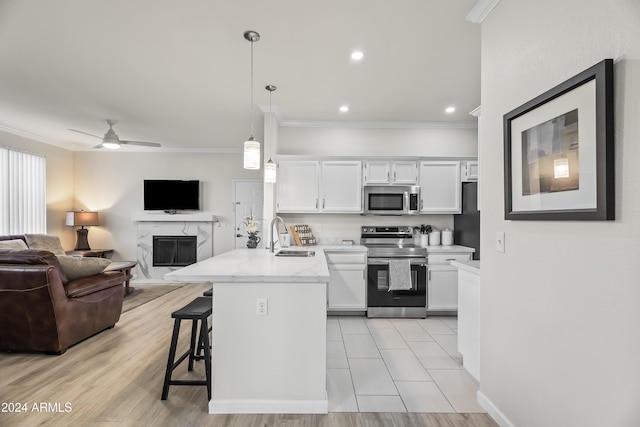 kitchen featuring sink, hanging light fixtures, ceiling fan, appliances with stainless steel finishes, and white cabinetry