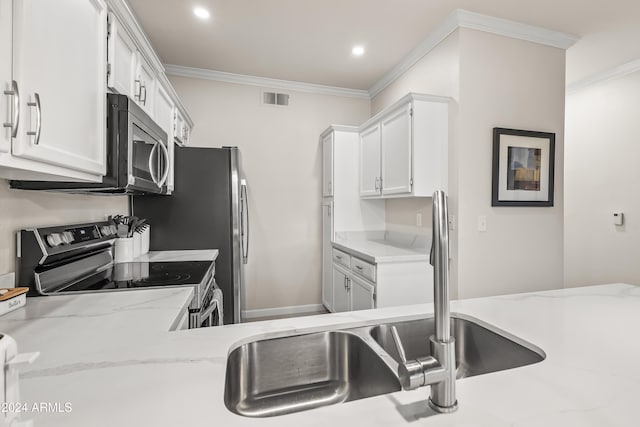 kitchen featuring stainless steel appliances, white cabinetry, and crown molding