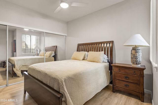 bedroom with a closet, light hardwood / wood-style flooring, and ceiling fan