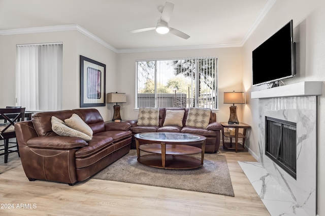 living room featuring ceiling fan, light wood-type flooring, and crown molding