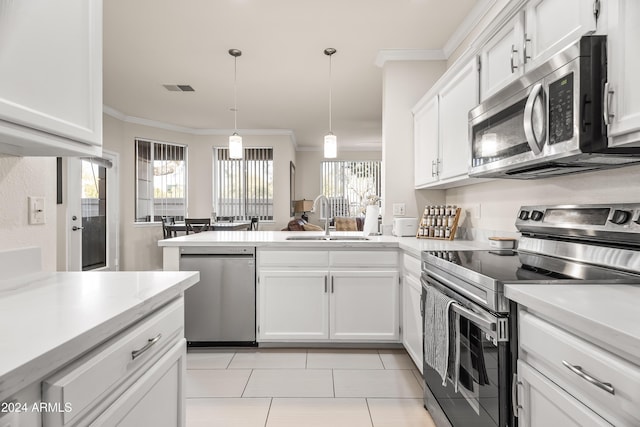 kitchen featuring appliances with stainless steel finishes, decorative light fixtures, white cabinetry, and sink