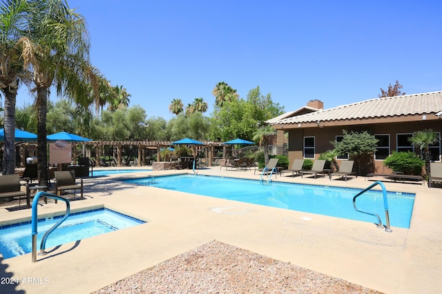 view of swimming pool with a patio area and a hot tub