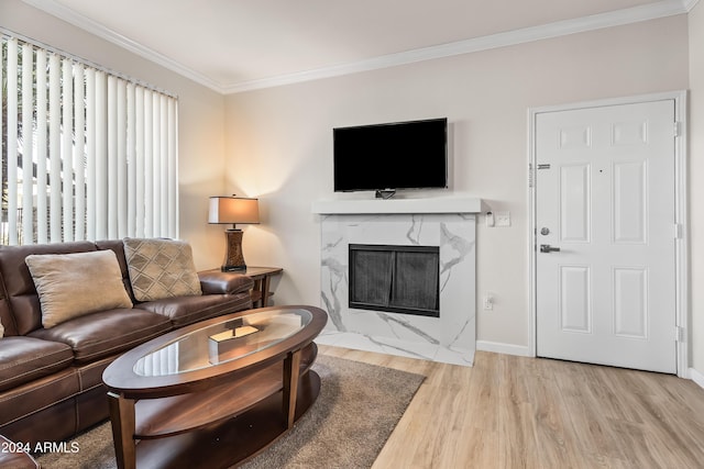 living room featuring light hardwood / wood-style flooring, a high end fireplace, and ornamental molding