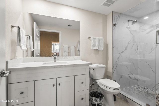 bathroom with vanity, toilet, and a tile shower