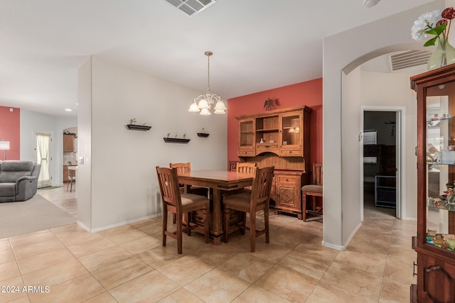 tiled dining space featuring an inviting chandelier