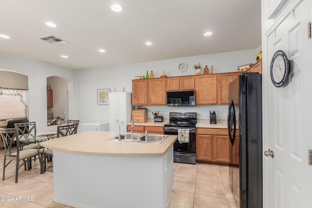 kitchen featuring sink, appliances with stainless steel finishes, a center island with sink, and light tile patterned flooring