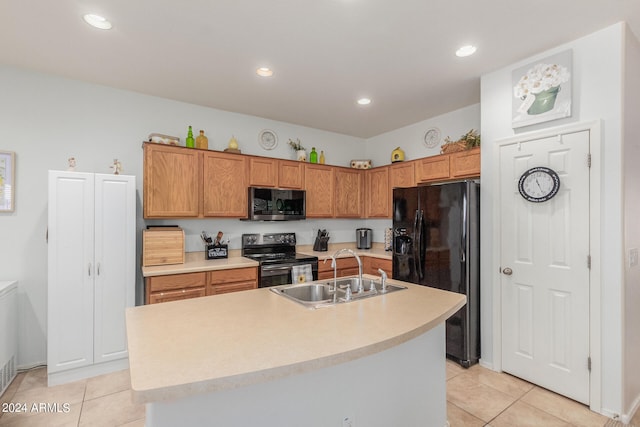 kitchen with light tile patterned floors, black fridge with ice dispenser, sink, electric range oven, and a center island with sink