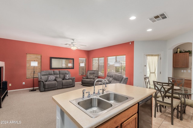 kitchen featuring light colored carpet, sink, black dishwasher, ceiling fan, and a center island with sink