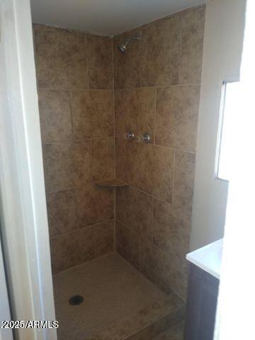 bathroom with vanity and tiled shower