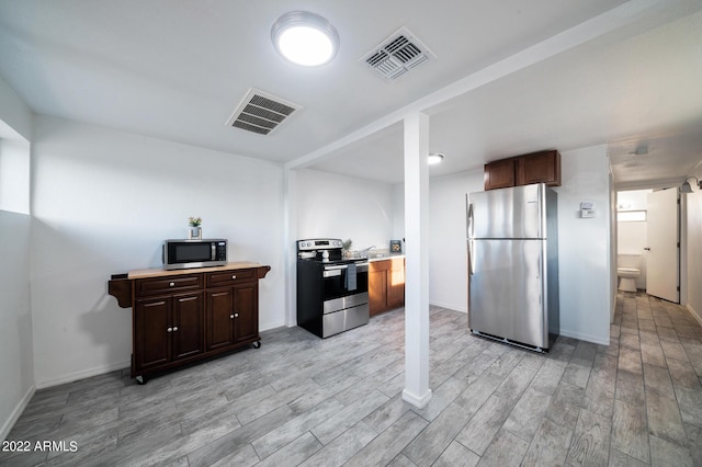 kitchen featuring dark brown cabinetry, appliances with stainless steel finishes, and light hardwood / wood-style floors