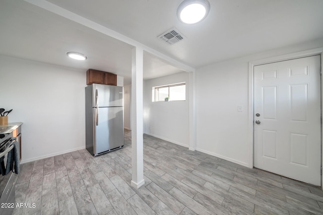 kitchen featuring stainless steel refrigerator and light hardwood / wood-style flooring