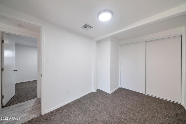 unfurnished bedroom featuring carpet floors and a closet