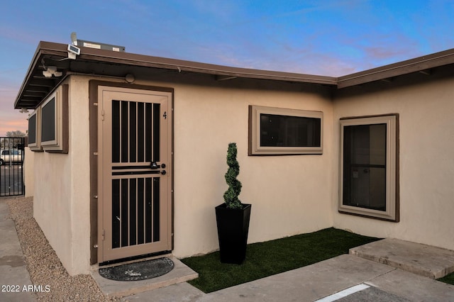 exterior entry at dusk featuring a patio