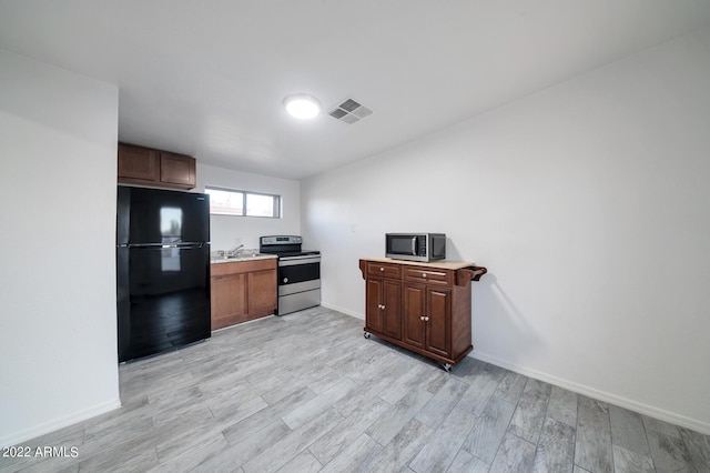 kitchen featuring light wood-type flooring, appliances with stainless steel finishes, and sink