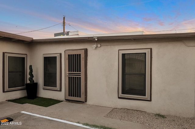 exterior entry at dusk featuring a patio