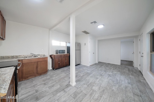 kitchen featuring white fridge, range with electric stovetop, light hardwood / wood-style flooring, and sink