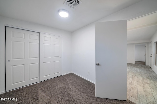 unfurnished bedroom with a closet and dark carpet