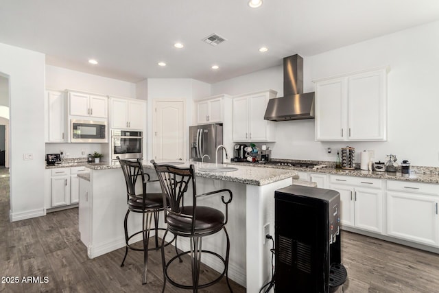 2052 E Scorpio Pl, Chandler, AZ 85249 - kitchen with wall chimney exhaust hood, stainless steel appliances, a center island with sink, white cabinets, and dark wood-type flooring